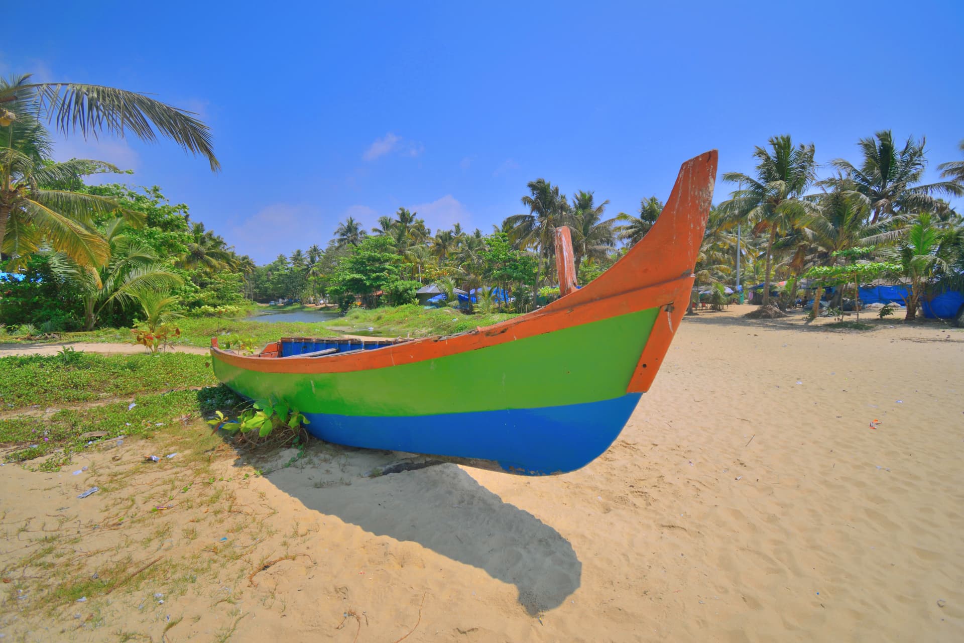 A colourful fishing boat on a sandy Kerala beach