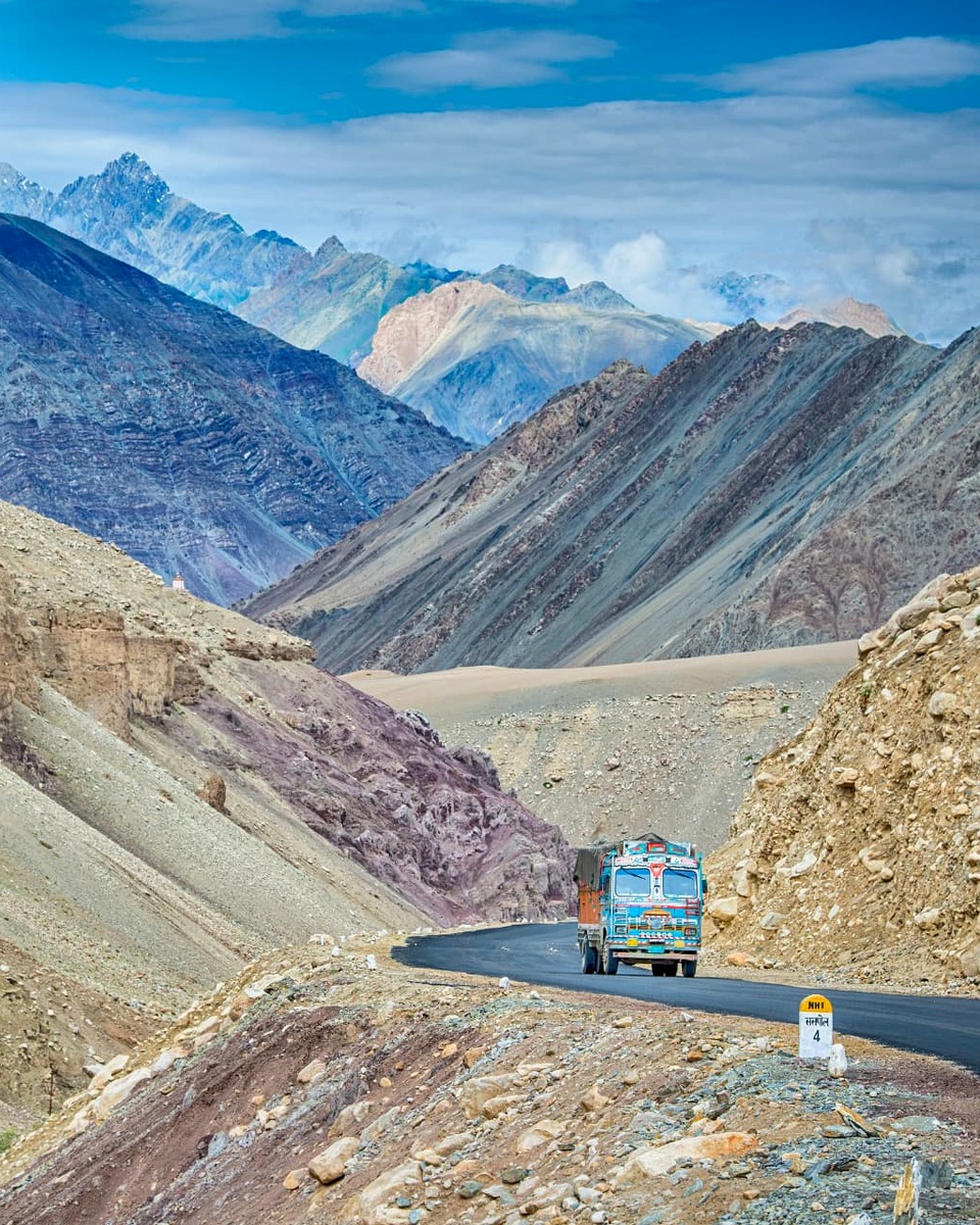 A colourful truck crossing a high mountain pass on an India discovery tour