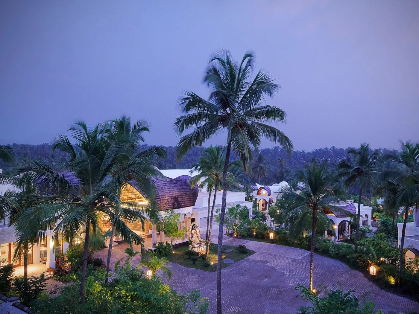 Evening view over the resort courtyard and coconut palms at Vivanta by Taj Bekal