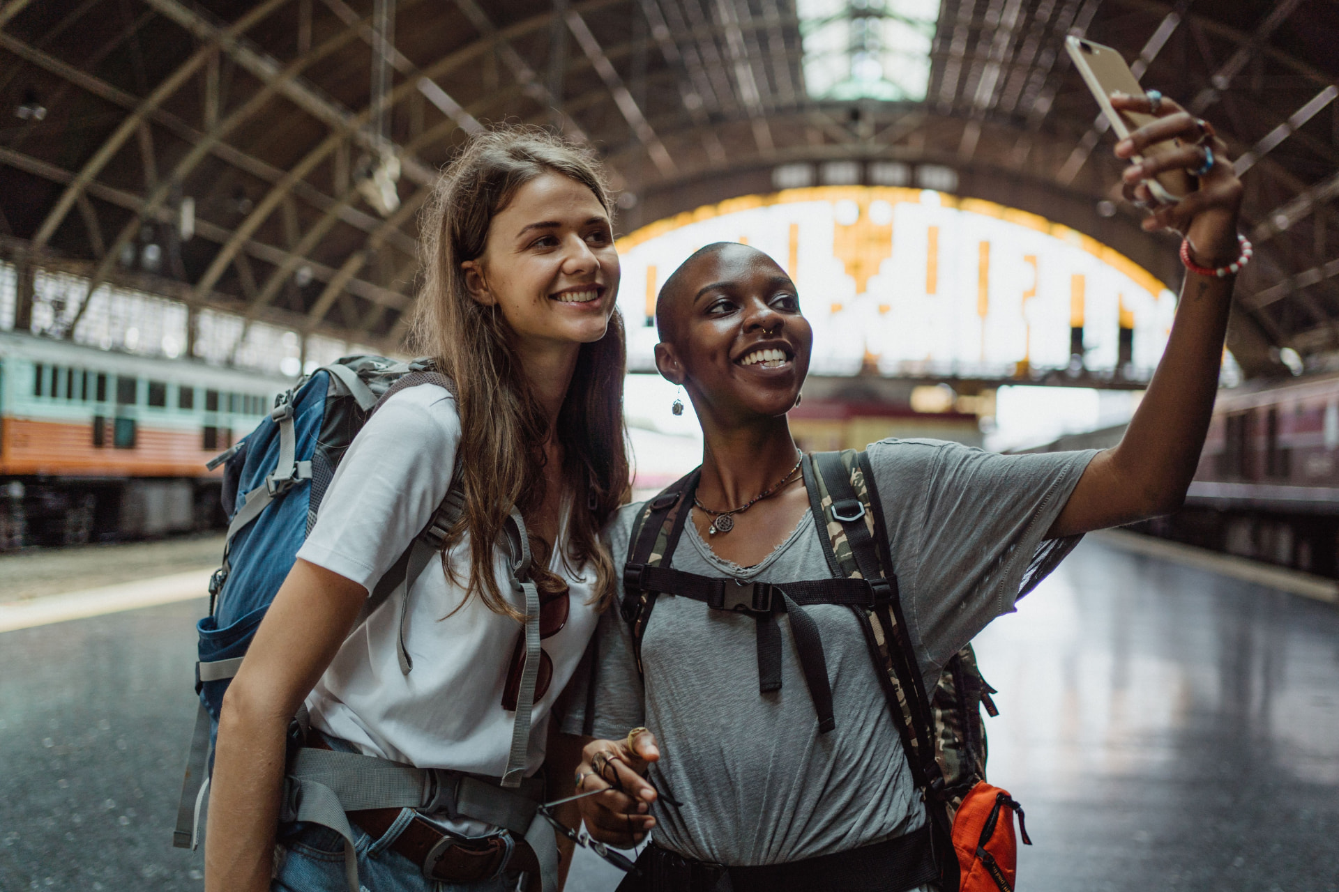 Two women travellers taking a selfie together at a railway station