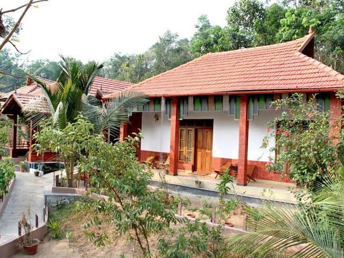 Tiled roof cottages and gardens at Mannaas Veedu Homestay in Pathanamthitta