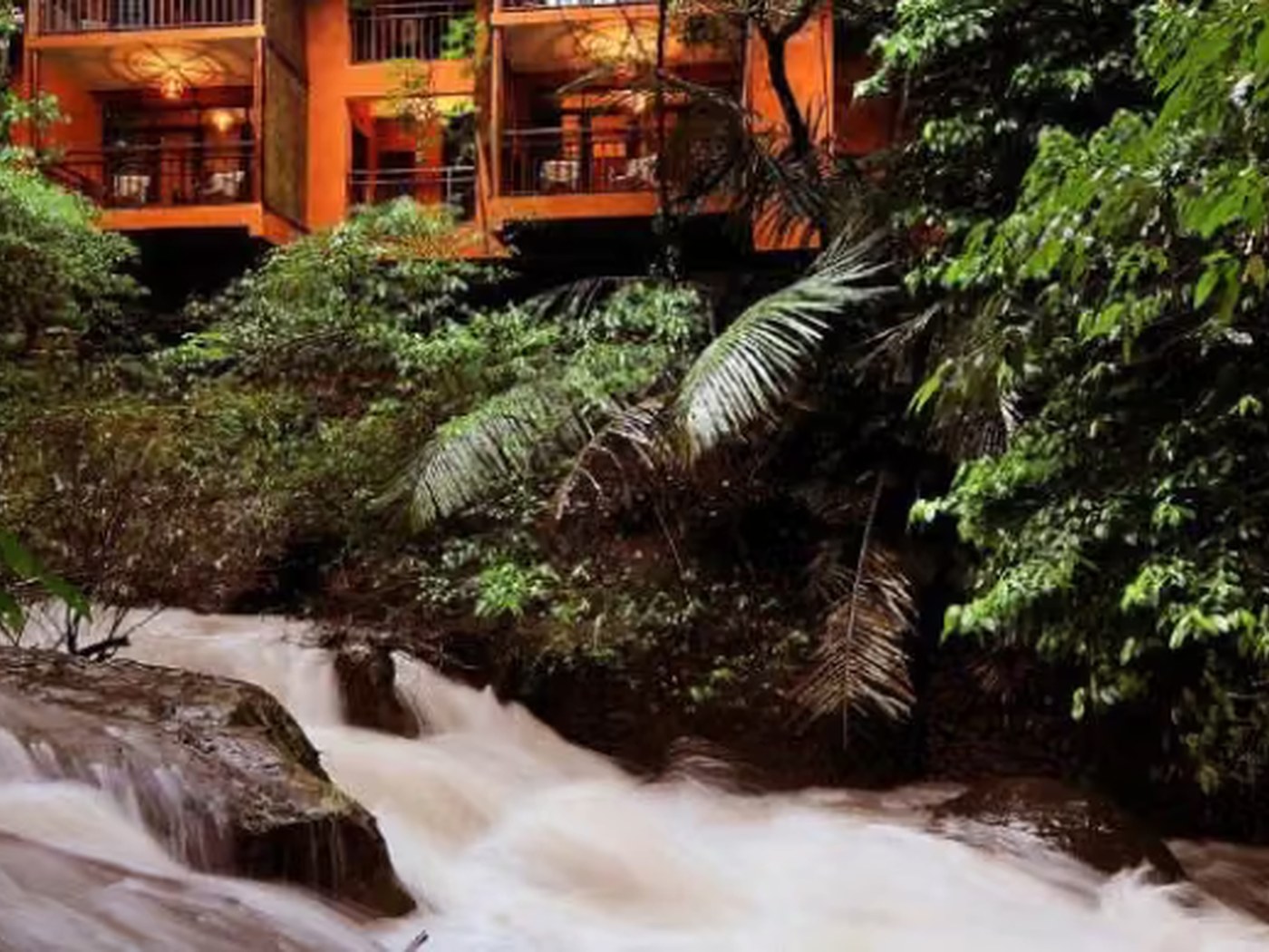 A view of cottages set in greenery, from the rocks near the water stream Vythiri Resort, Wayanad at Vythiri Resort