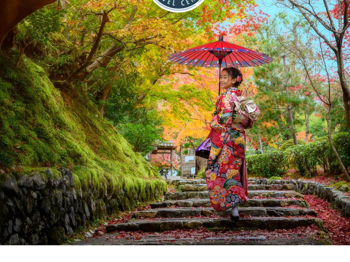 A woman in kimono on stone steps in an autumn forest