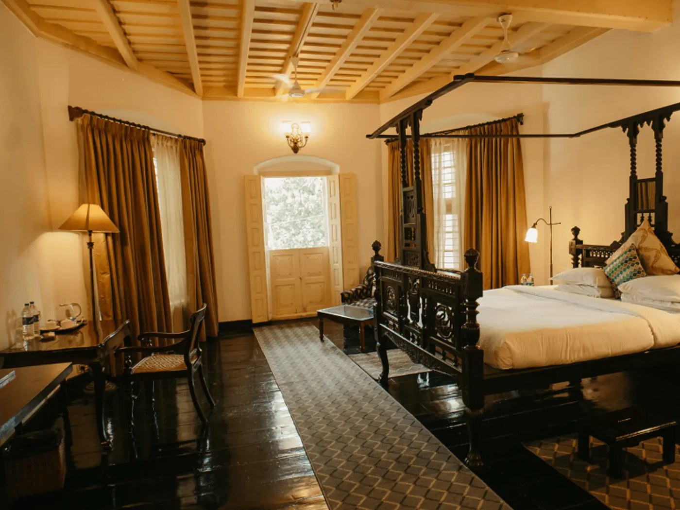 Suite at Koder House with a carved four poster bed and polished wooden floor