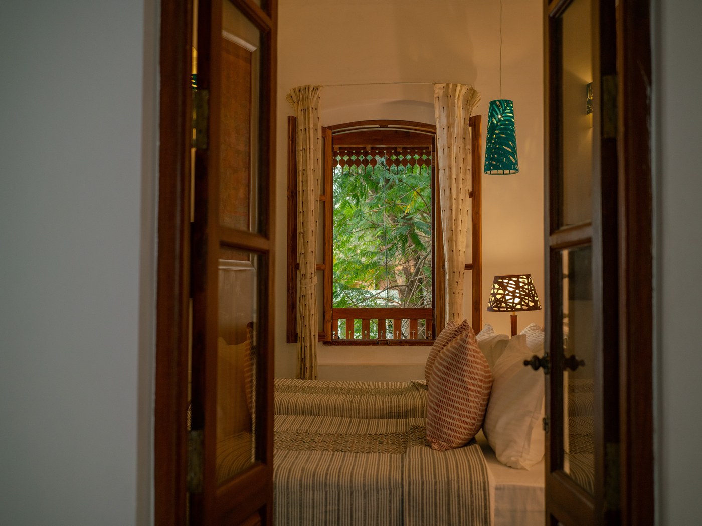 Bedroom with tall shutters at Résidence de l'Evêché