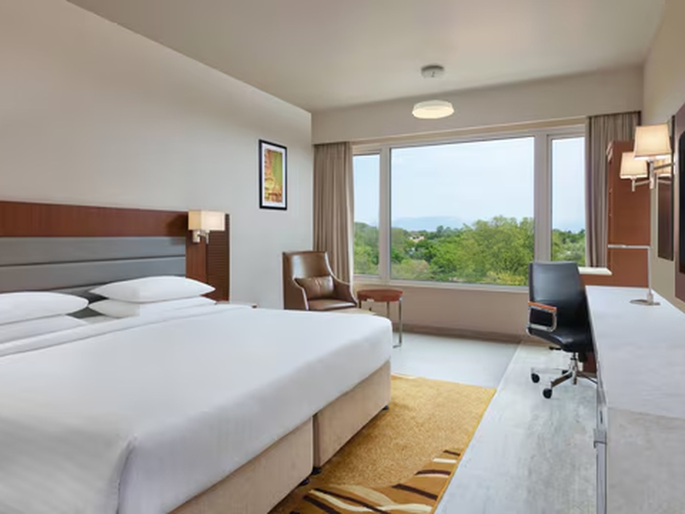 Guest room with a work desk and views over the hills at Marriott Madurai