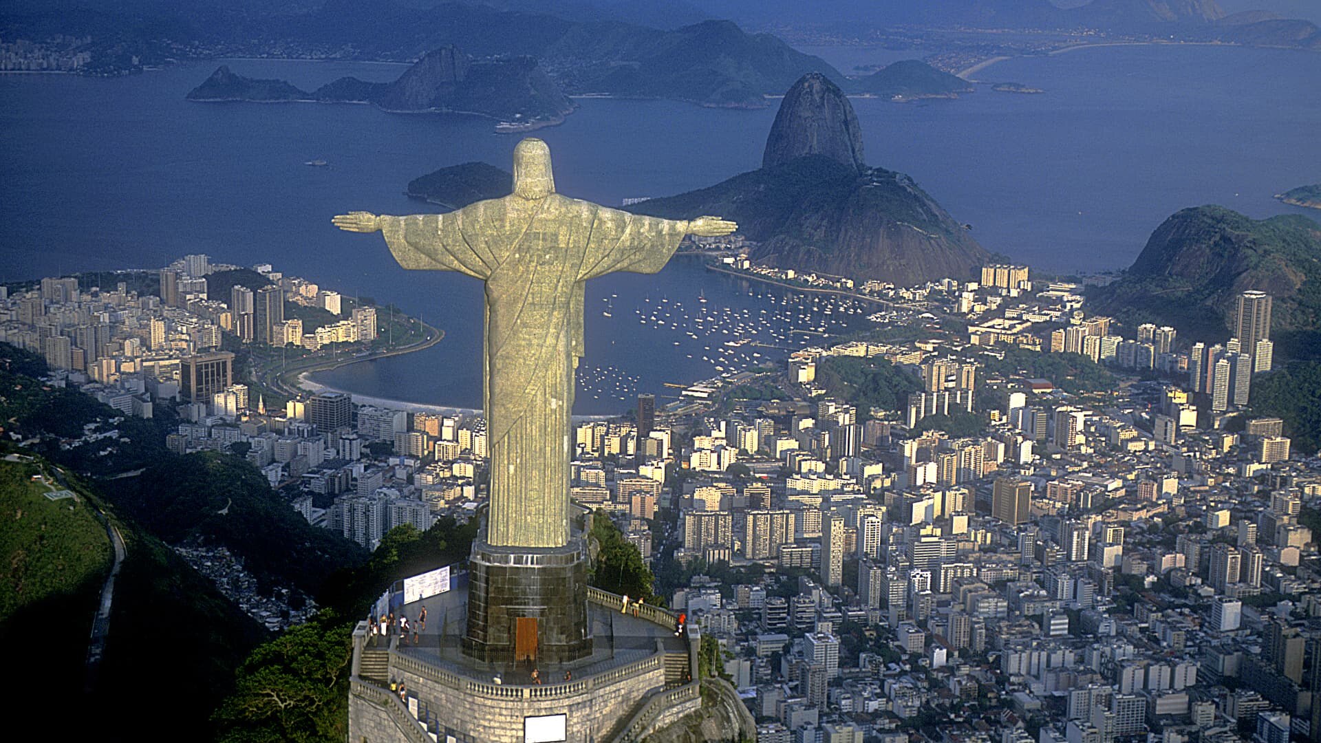 Christ the Redeemer above Rio de Janeiro with Sugarloaf mountain and Guanabara bay at dusk