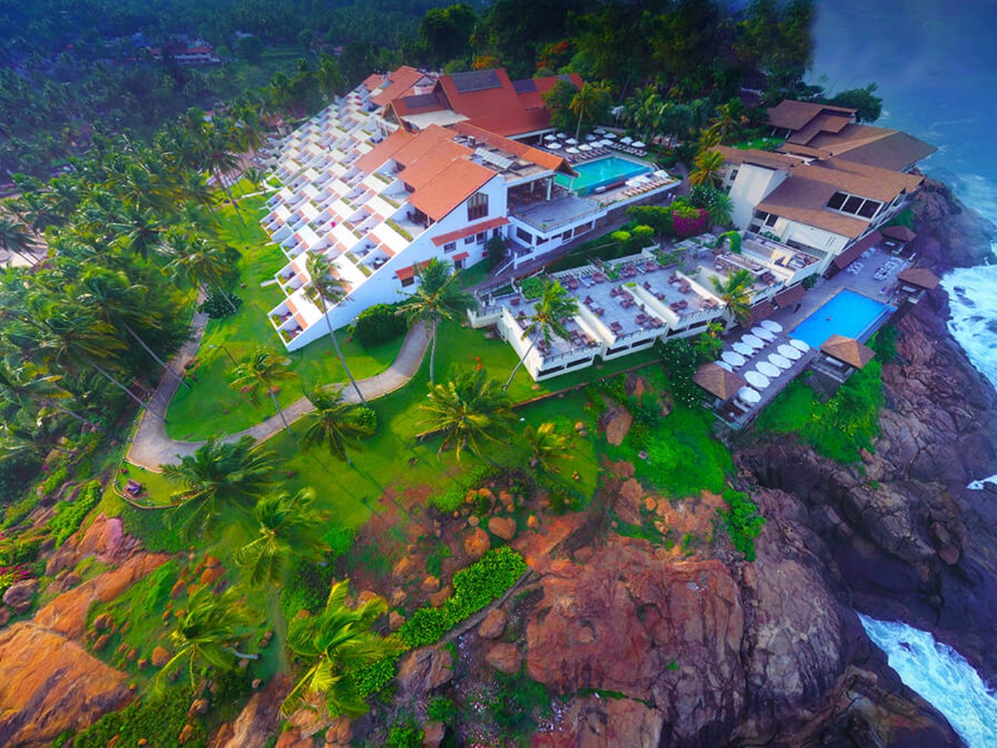A clifftop luxury resort pool overlooking the Kerala coast